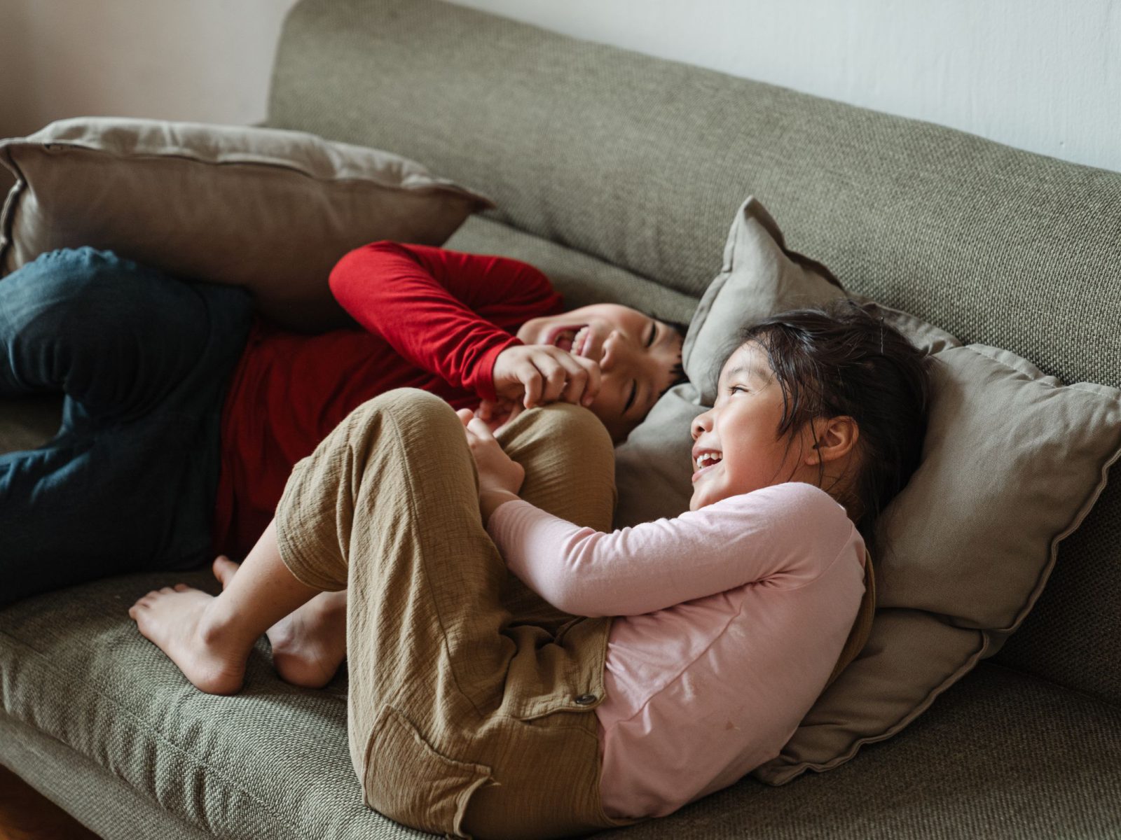 Mother and daughter laughing on the sofa