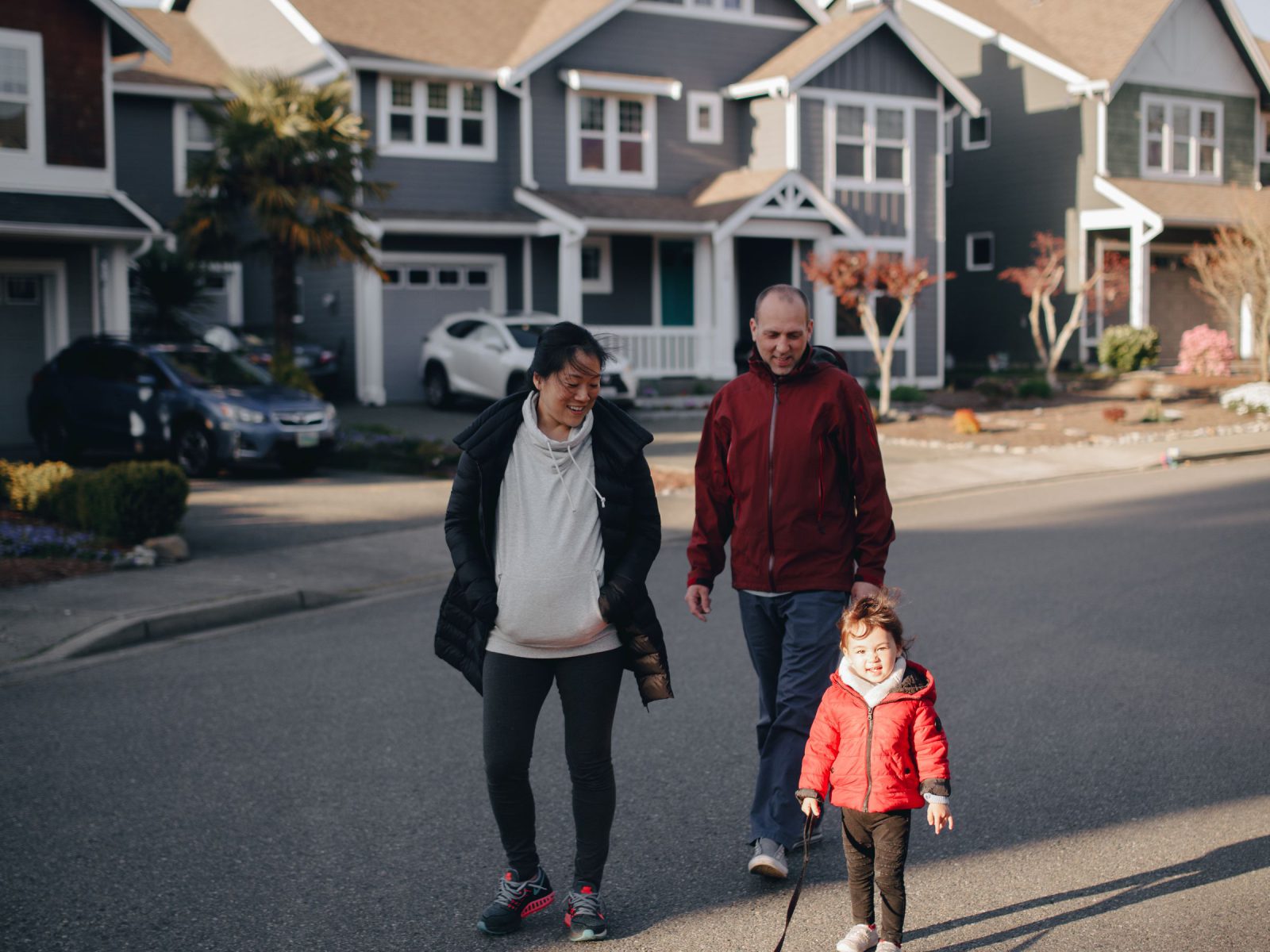 A family walking their dog on a quiet residential street